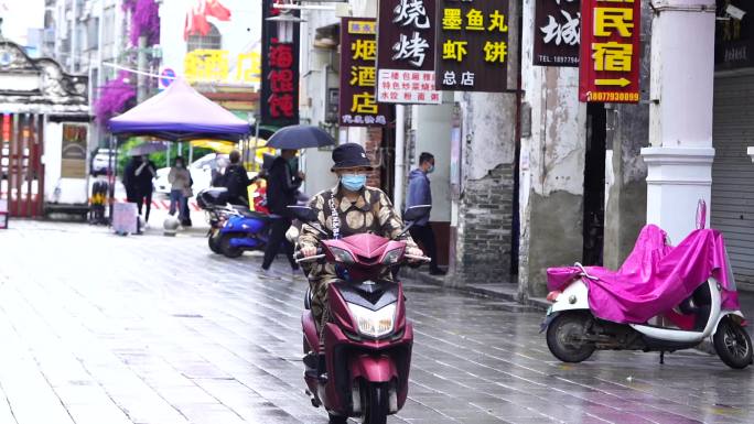 雨天老街骑摩托的人