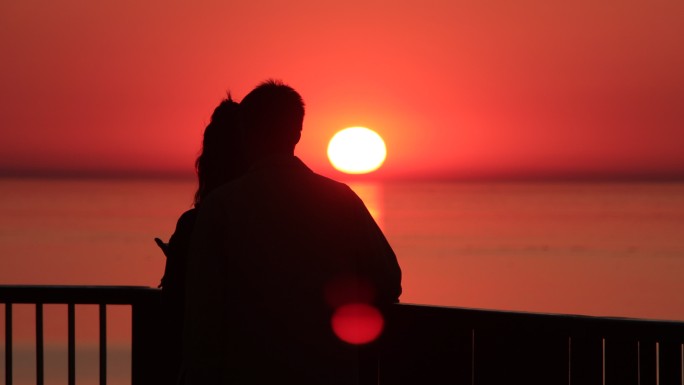 海边看夕阳的情侣剪影