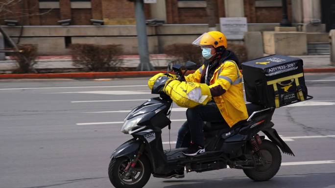 沈阳城市马路上飞驰的外卖员