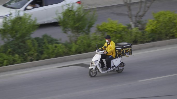 外卖骑手行驶在马路上