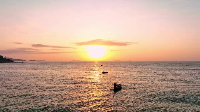 海上日出小船海面金色光芒早晨渔民在打鱼