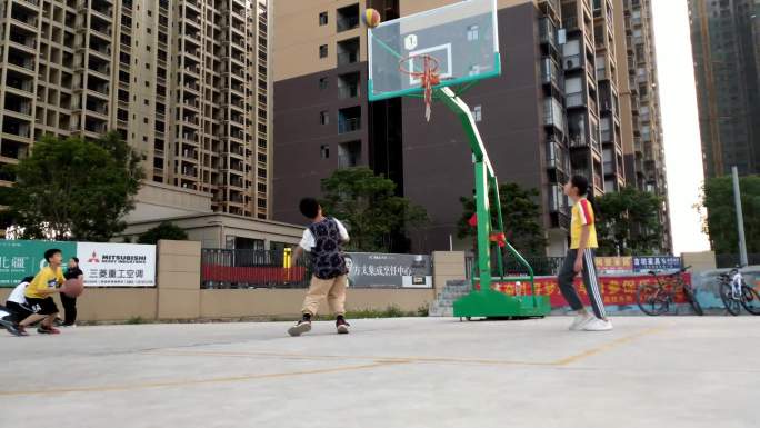 在小区球场打篮球的小孩们打篮球