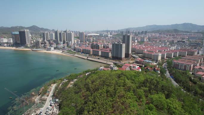 航拍初夏时节青翠的山岗和海滨城市