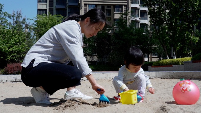 年轻妈妈在小区里哄孩子