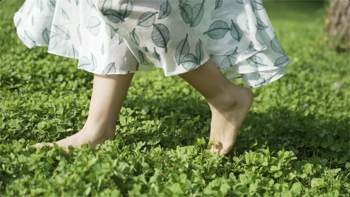 女孩光脚走在草地上，走进自然亲近自然