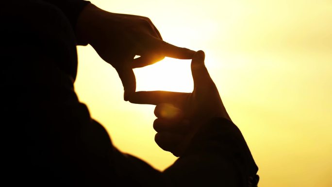拍照手势手比拍照姿势用指框相机观看日落