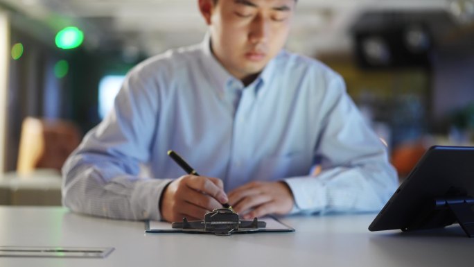 年轻商务人士抄写记录平板电脑上的内容