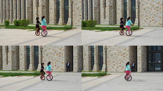 两个女孩牵手骑独轮车