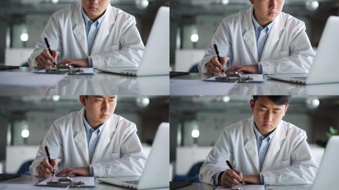 年轻医学科研人员记录抄写笔记本电脑内容