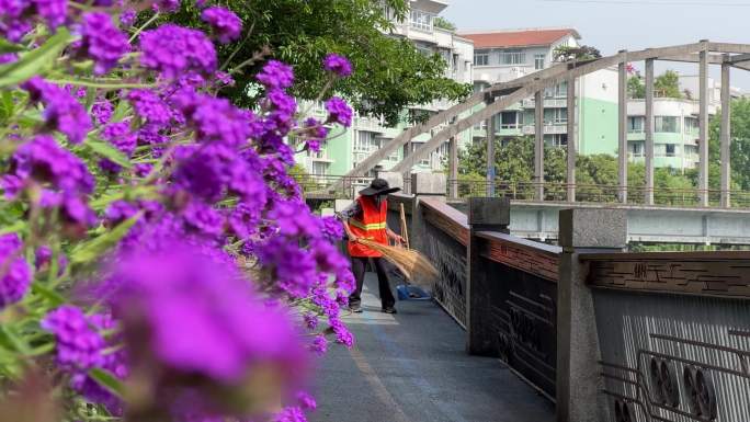 城市绿道花丛后清洁工环卫工人清扫栏杆4K