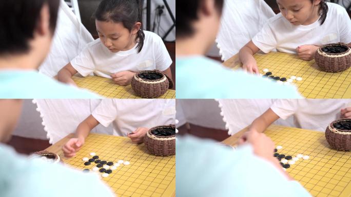 坐在地上下围棋的母女