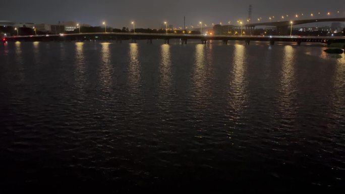 夜晚灯光照在水面上波光粼粼道路路灯湖面