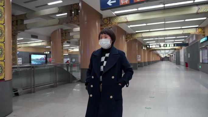 冬天在地铁站内快步行走的东方女性