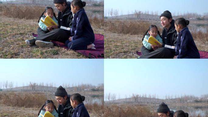 父亲坐在草地上陪女儿看书