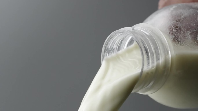 慢镜头拍摄瓶口倾倒中的牛奶
