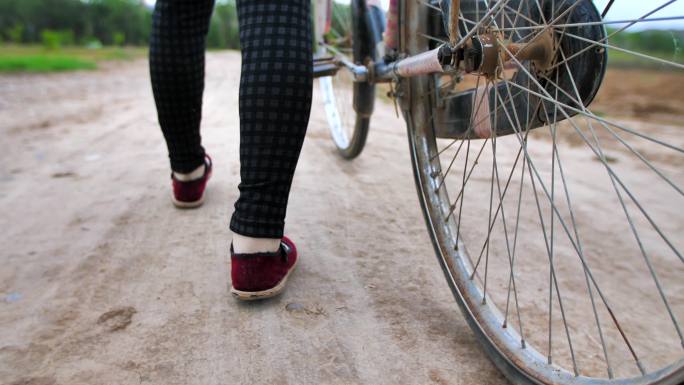 田野间老自行车农村妇女的脚步4K高速摄影