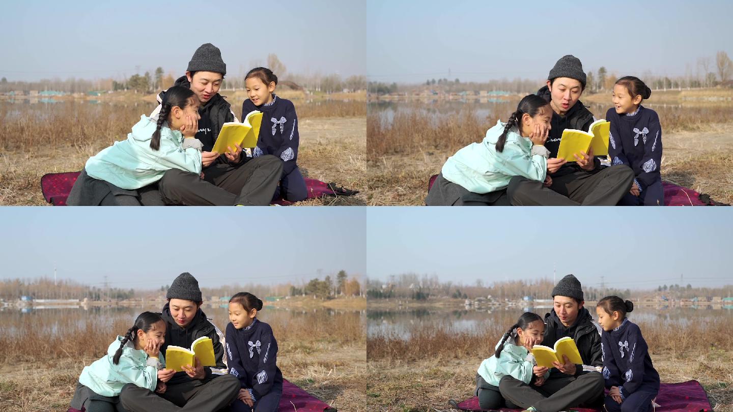 父亲坐在草地上陪女儿看书