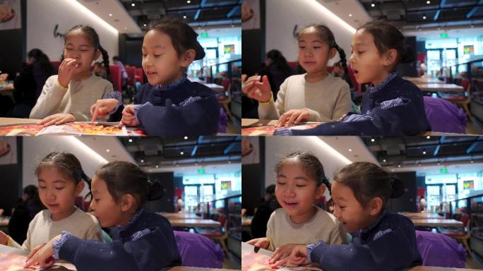在餐厅翻阅菜单点餐的两个亚洲女孩