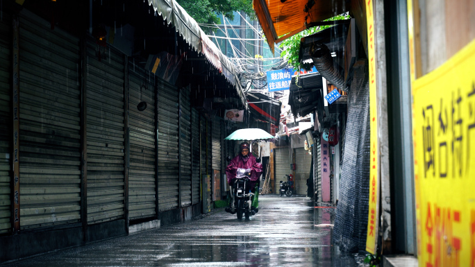 下雨天巷子街道老街路上电动车