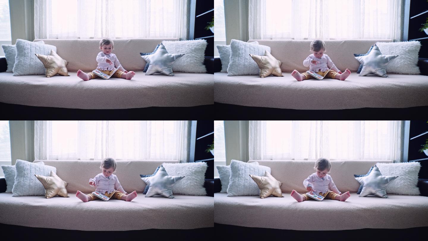 宝宝在沙发上看书，浏览图片。