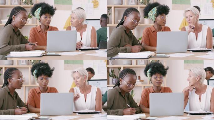 一群女商人坐在办公室的桌子旁，一边使用笔记本电脑一边聊天