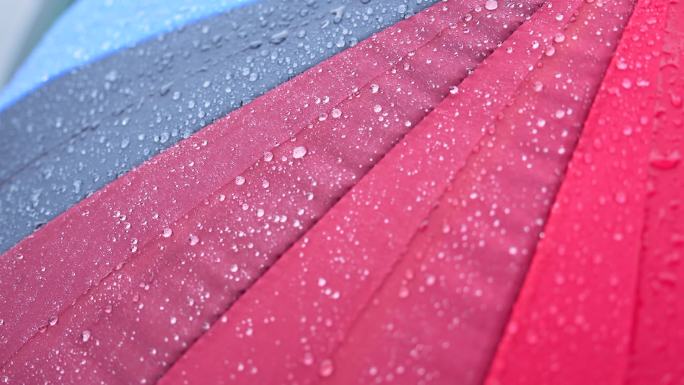 4K正版-下雨天雨滴落在彩色伞面上