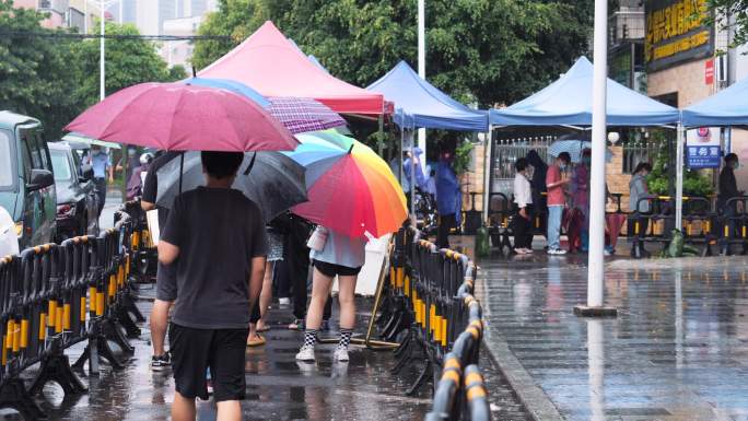 4K正版-下雨天有序排队做核酸检测的居民