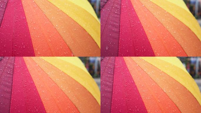 4K正版-暴雨中的雨滴落在彩色伞面上