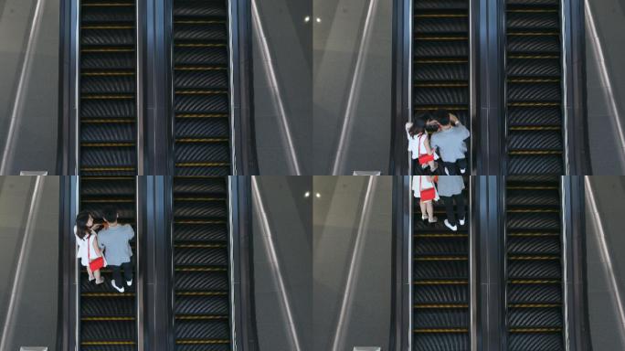 一对亚裔夫妇在购物中心的自动扶梯上