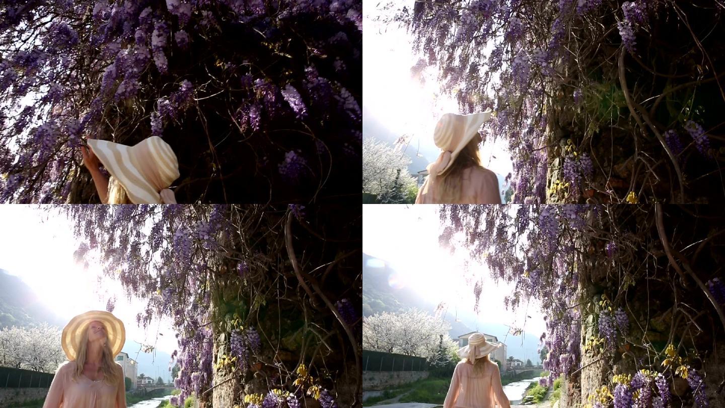 女人走过紫藤花，停下来享受香水