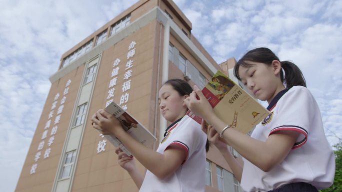 在操场上看书的学生中学生