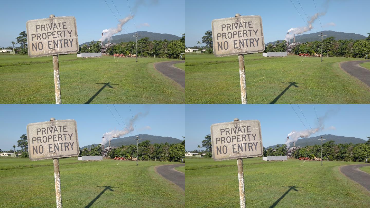 昆士兰北部热带地区一家糖厂烟囱空气污染旁边的私人房产标志