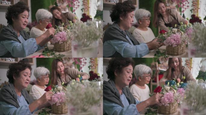 亚裔华裔高级女性在花店向女花匠学习插花