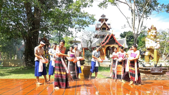 4K泼水节——泼水节当天，美丽的女性穿着传统的泰国服装向寺庙里的男性泼水