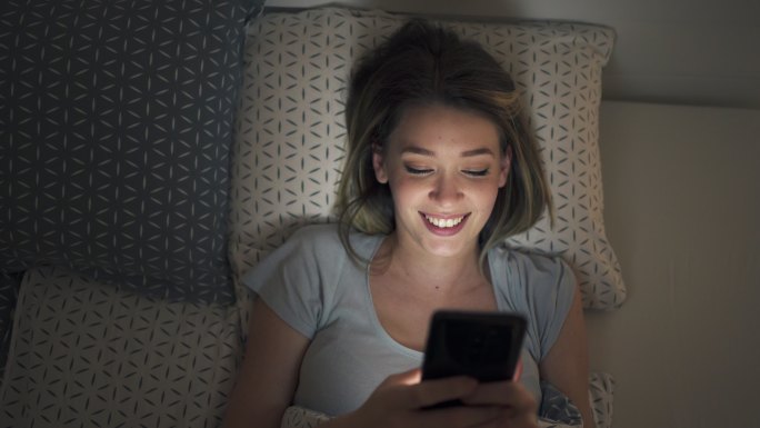 晚上在社交媒体上发短信给恋爱中的快乐年轻女性