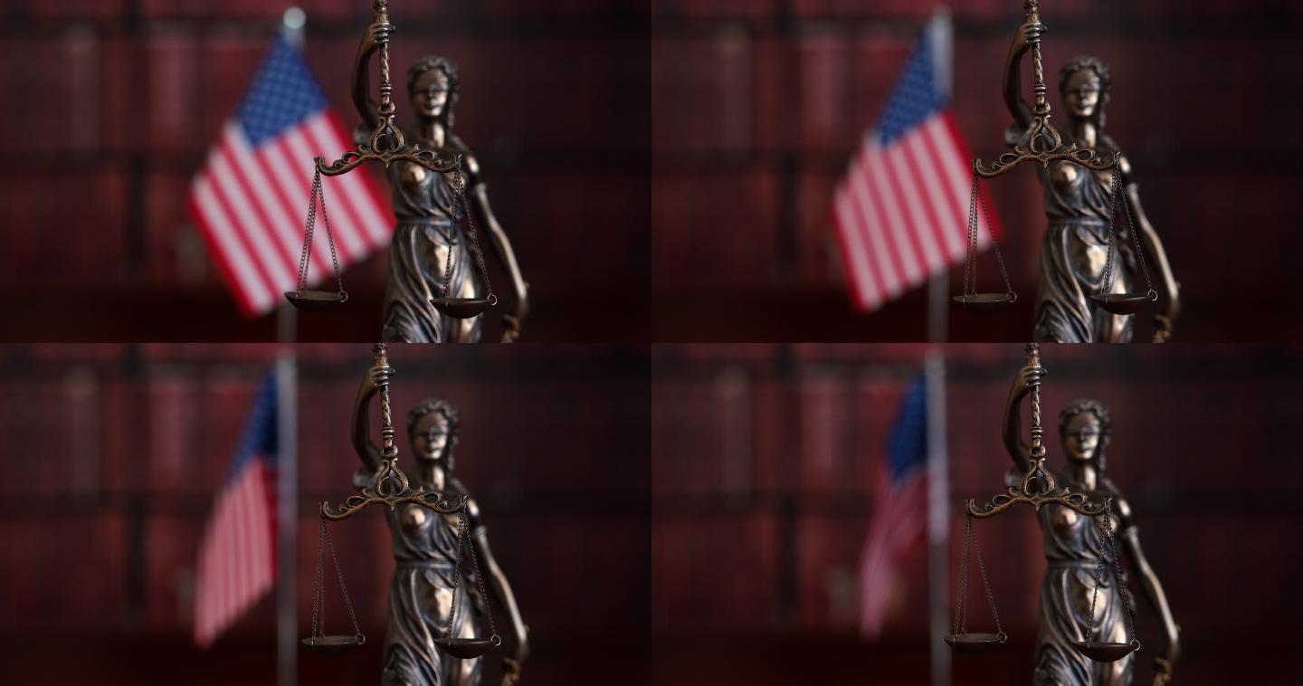 法律书籍和美国国旗前的正义雕像