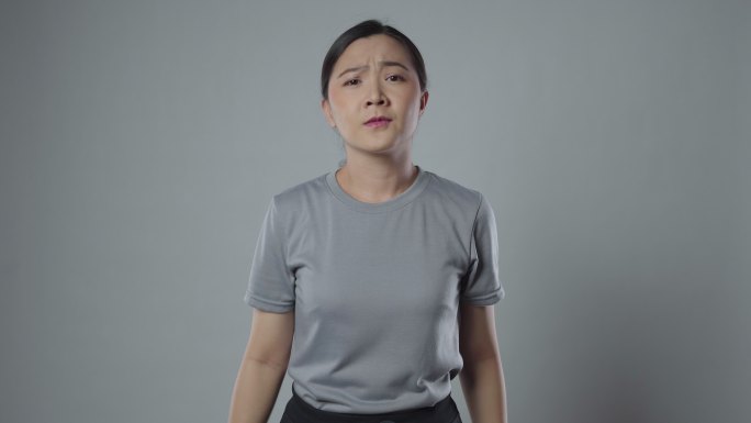 一名亚洲女子交叉双臂示意停车。