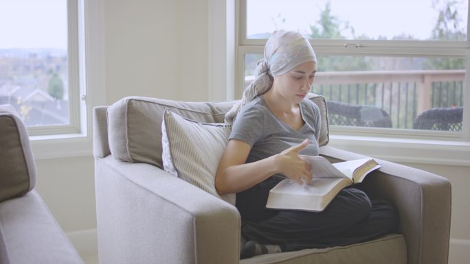 患有癌症的少数民族年轻女性阅读圣经