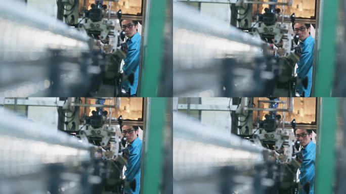 在瓶装厂矿泉水饮用水厂操作贴标机的亚裔中国男性生产线工人