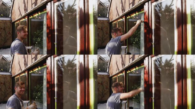 肖像自信男画家在房屋外部绘制窗户装饰