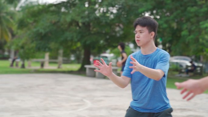 慢动作Z代亚裔中国少年在周末早上和朋友练习篮球比赛时打篮球