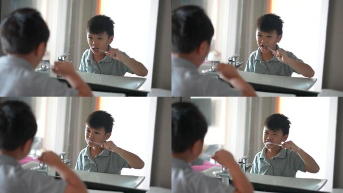 亚洲小孩在洁白干净的浴室刷牙。日常健康和牙齿护理的概念