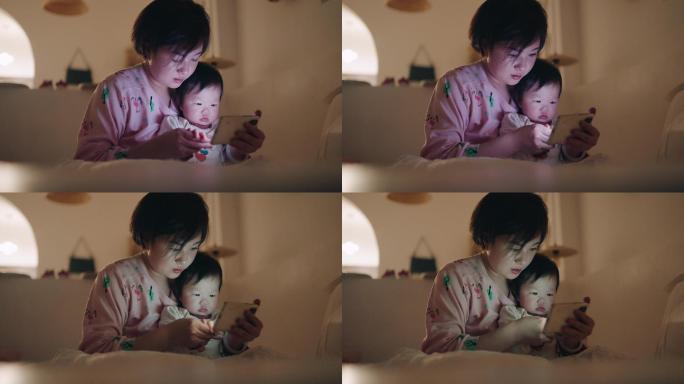 亚洲母女在床上使用智能手机
