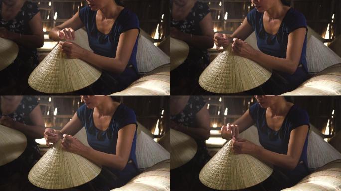 4k镜头的微光场景特写，越南工匠在越南坎托省阿披福村的传统老房子里制作传统越南帽子，传统艺术家概念