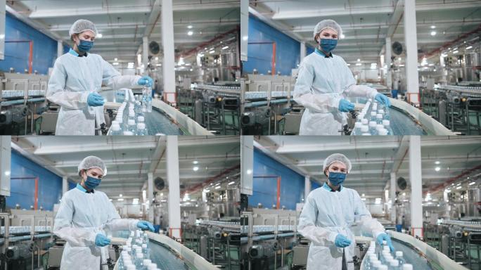 肖像亚裔中国饮用水厂生产线女工戴着PPE检查水瓶日常工作