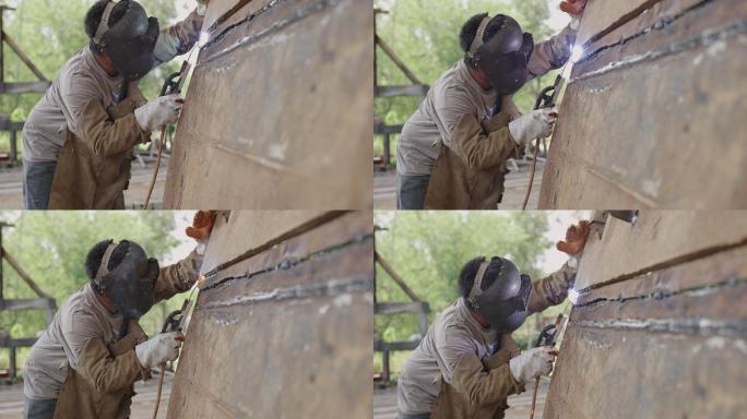 电焊工固定大锈金属板长裂纹的仰射