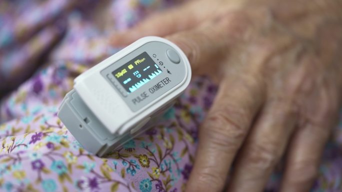 老太太用脉搏血氧仪测量她的血氧饱和度
