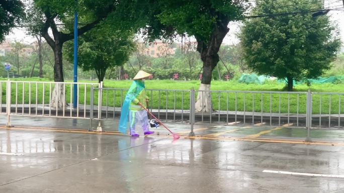 下雨天在马路中央扫地的环卫工