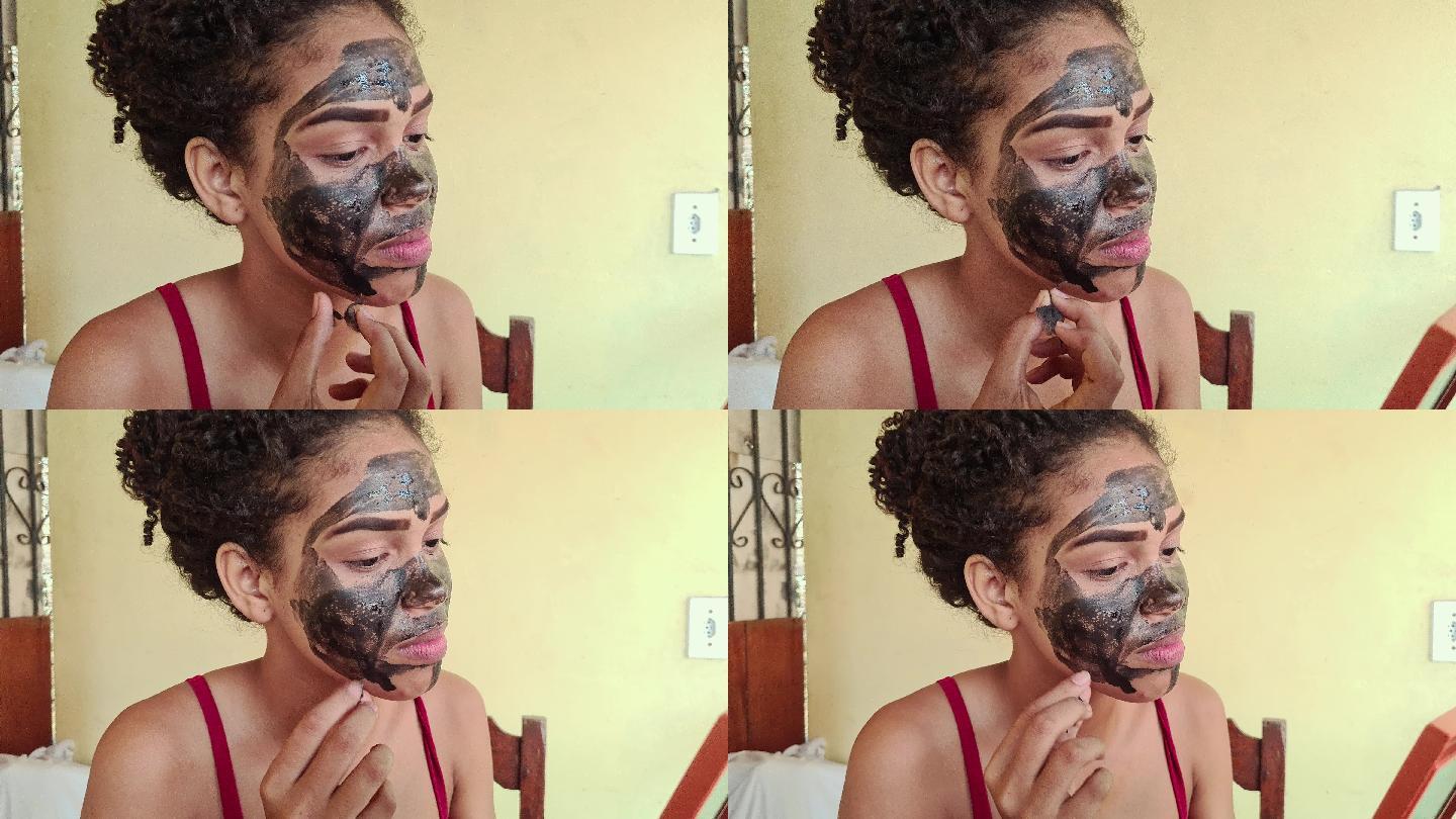 一位黑人妇女正在做一个关于摘下面膜进行面部皮肤护理的实时视频教程
