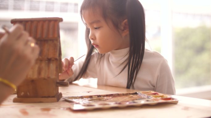 小女孩和妈妈在模型房里画画